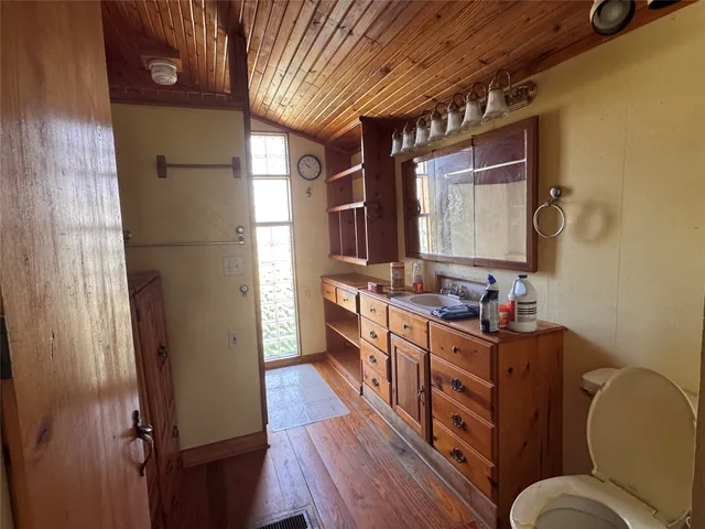 a kitchen with stainless steel appliances granite countertop a refrigerator a sink dishwasher a stove and white countertops with wooden floor