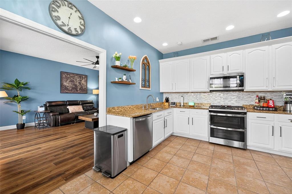 413 Rockafellow Way Orlando, FL 32828 - Photo 39 of 88 a large kitchen with stainless steel appliances granite countertop a stove and a sink