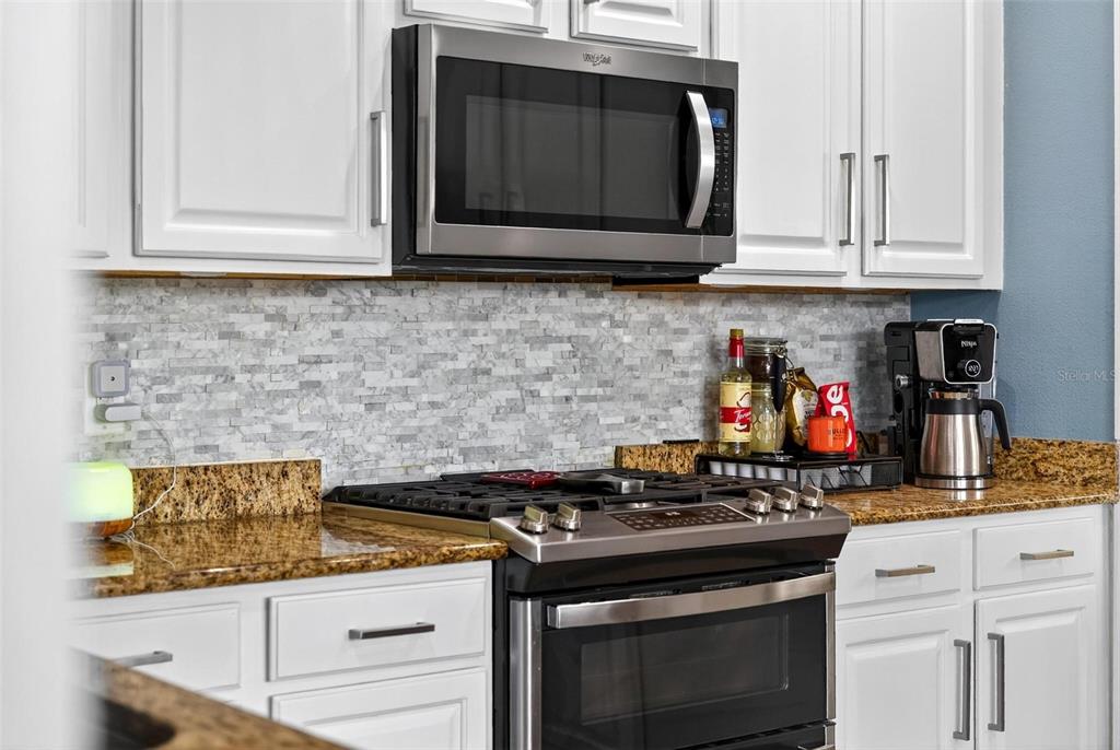 413 Rockafellow Way Orlando, FL 32828 - Photo 41 of 88 a kitchen with stainless steel appliances granite countertop white cabinets and black stove top oven with granite countertops
