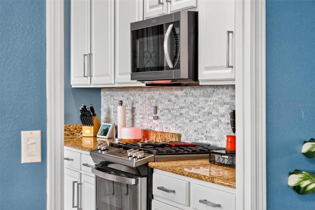 413 Rockafellow Way Orlando, FL 32828 - Photo 45 of 88 a kitchen with stainless steel appliances granite countertop a stove and a microwave