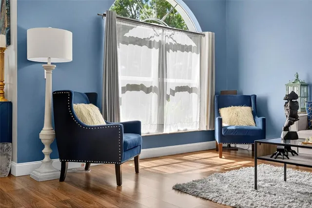 a living room with furniture and a large window with wooden floor