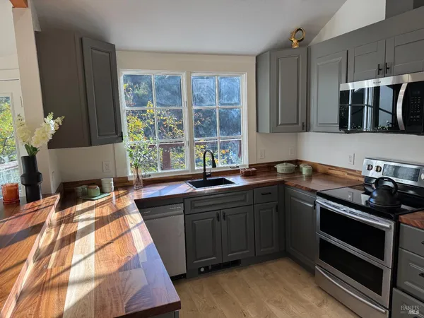 a kitchen with stainless steel appliances kitchen island granite countertop a sink stove and cabinets