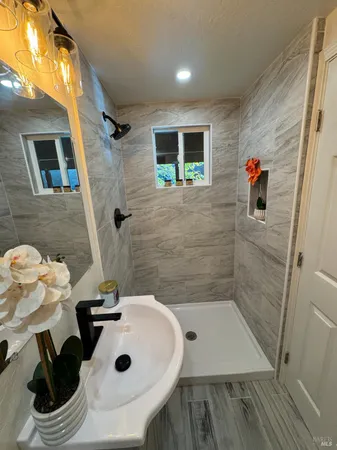 a bathroom with a sink a toilet and shower
