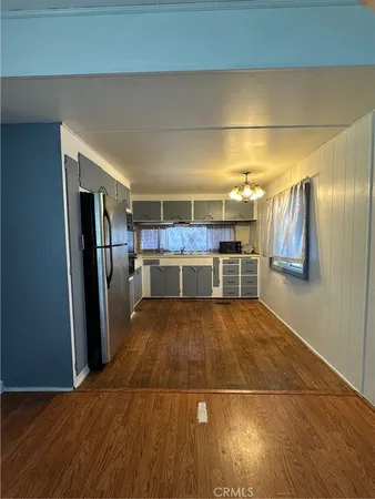 a room with stainless steel appliances kitchen island granite countertop a refrigerator and microwave