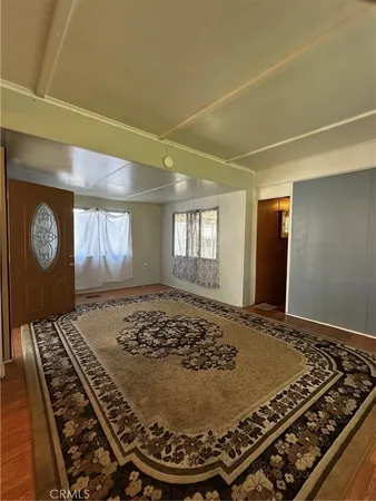 a bed sitting in a bedroom next to a window and a chandelier