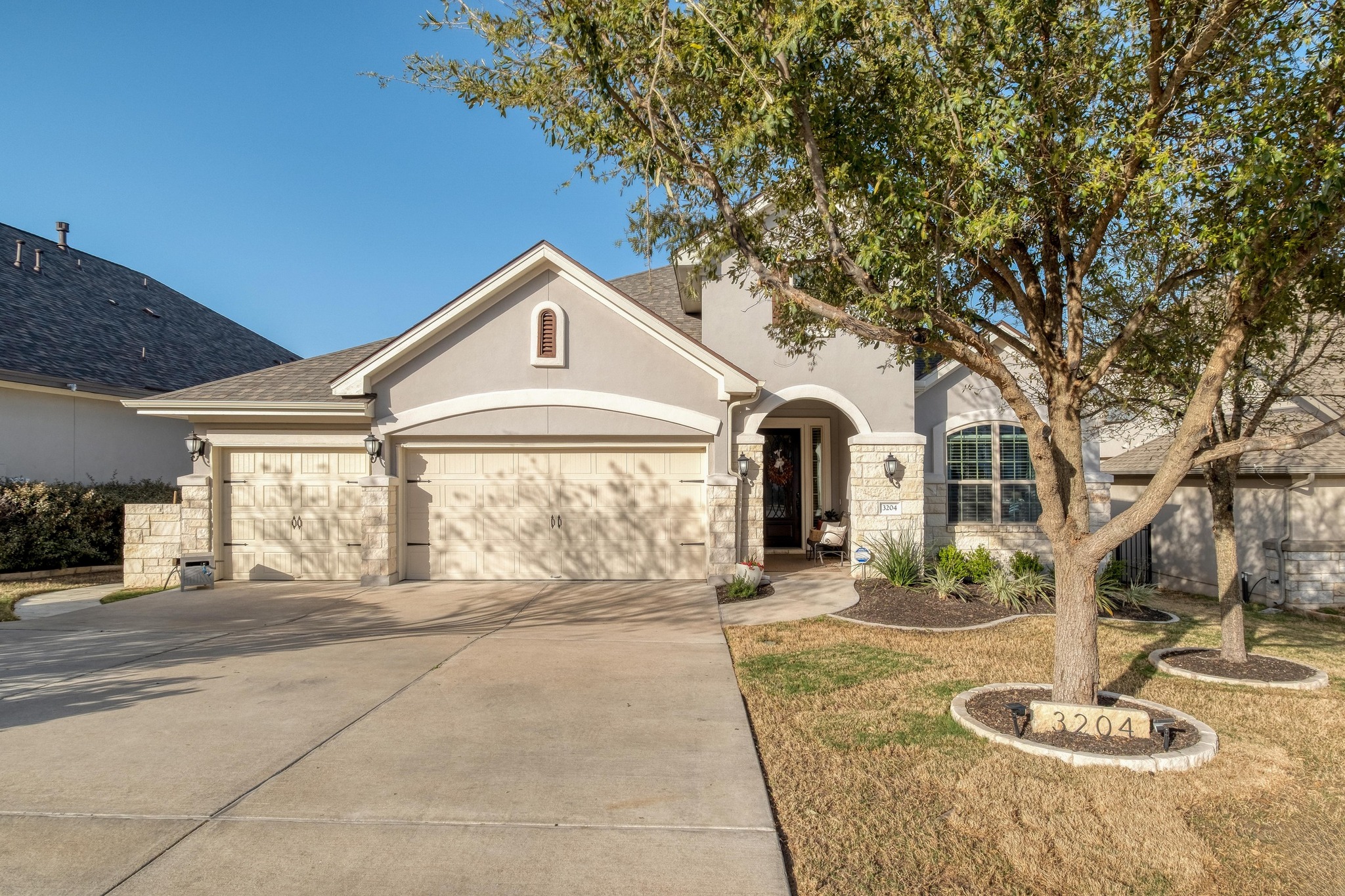 View of front of property featuring landscaping and 3-car garage