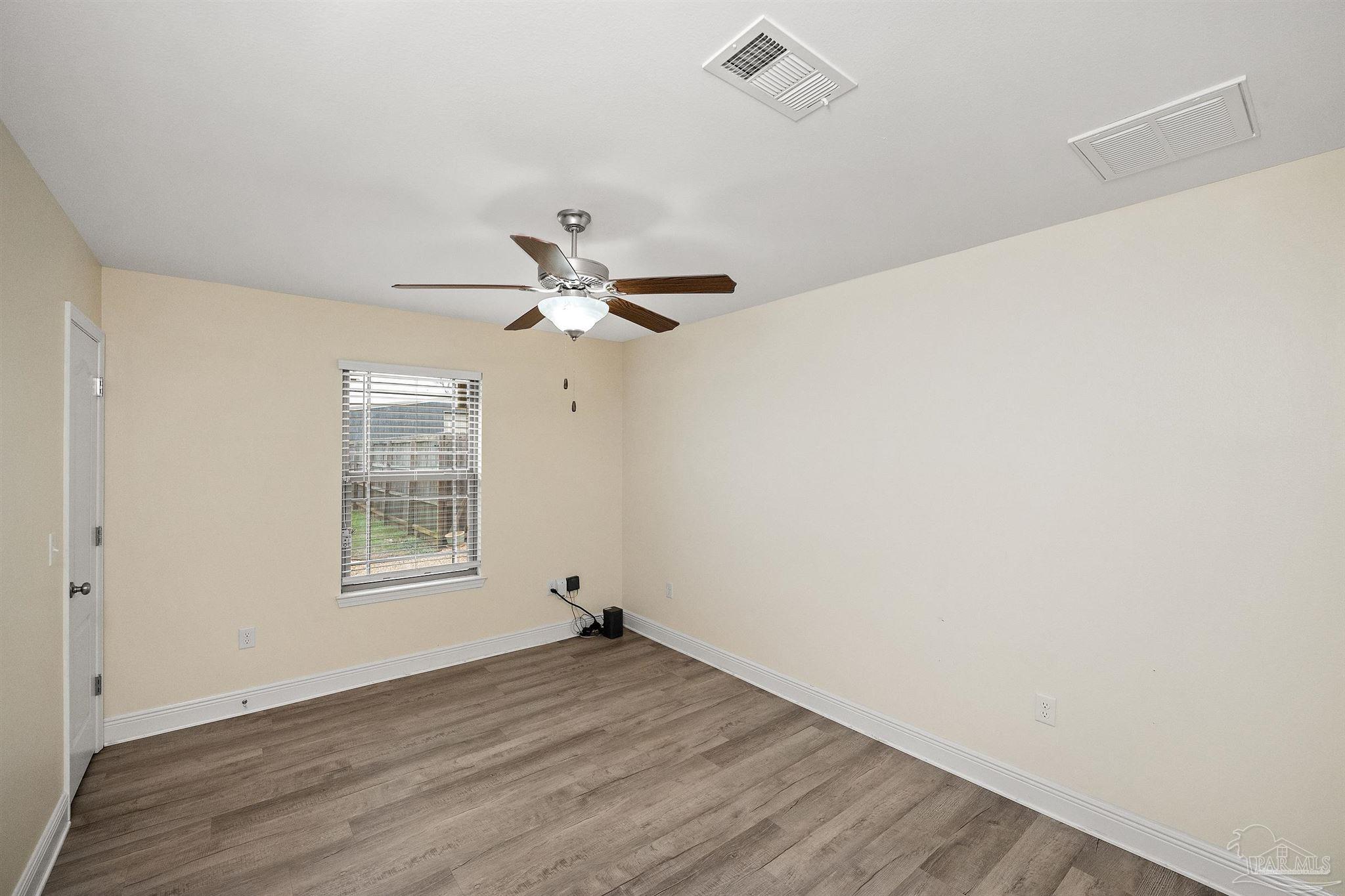 3500 Hazel Godwin Road Jay, FL 32565 - Photo 39 of 67 an empty room with wooden floor fan and windows