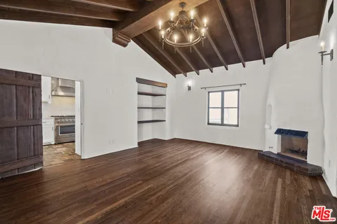 a view of empty room with wooden floor fireplace and window