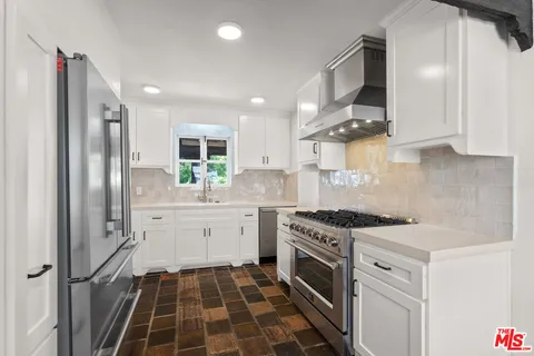 a kitchen with a stove a sink and a refrigerator