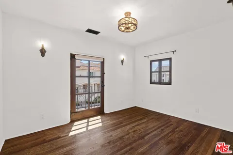 an empty room with wooden floor and window