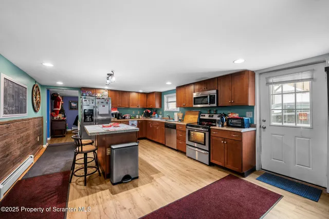a kitchen with stainless steel appliances granite countertop a stove top oven a sink dishwasher and cabinets with wooden floor