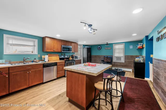a kitchen with stainless steel appliances granite countertop wooden cabinets a stove a sink and a refrigerator