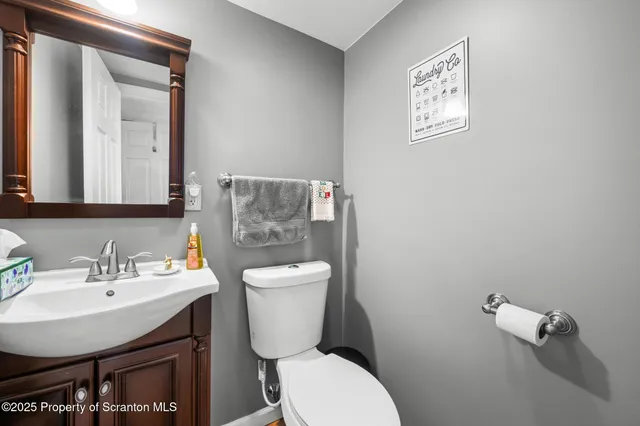 a bathroom with a toilet a sink and mirror