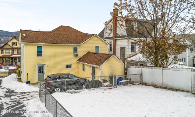 a view of a house with a yard and wooden fence