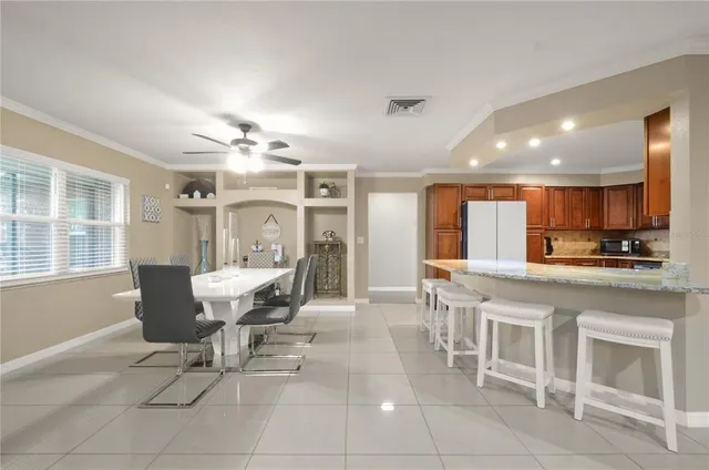 a dining room with furniture and view of kitchen