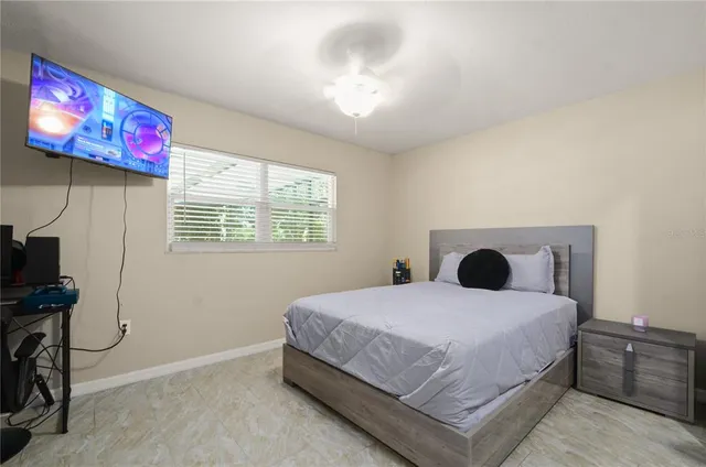 a bedroom with a bed and a flat screen tv