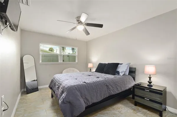 a bedroom with a bed a chandelier and a window