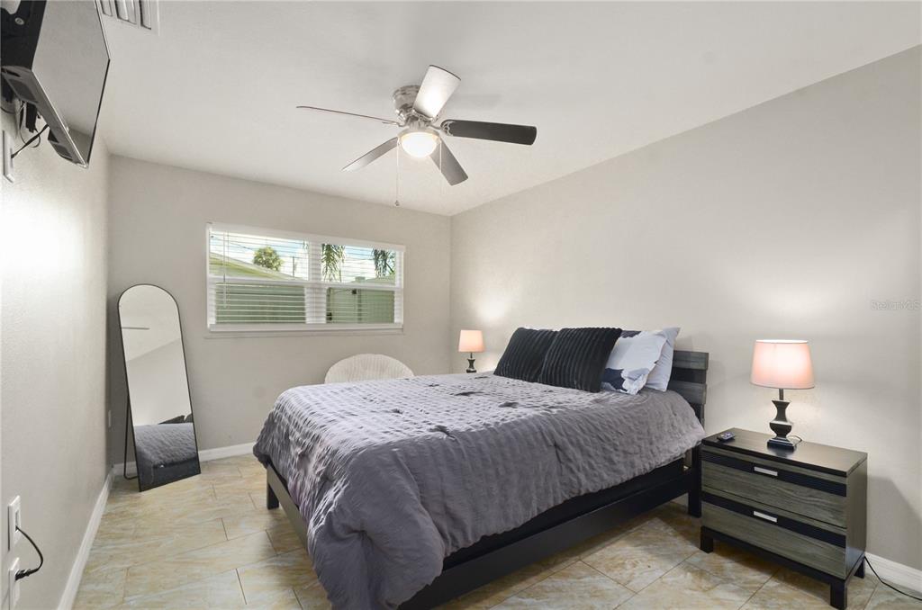 209 7th Street South Dundee, FL 33838 - Photo 24 of 36 a bedroom with a bed a chandelier and a window