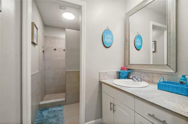 a bathroom with a sink a mirror and a shower