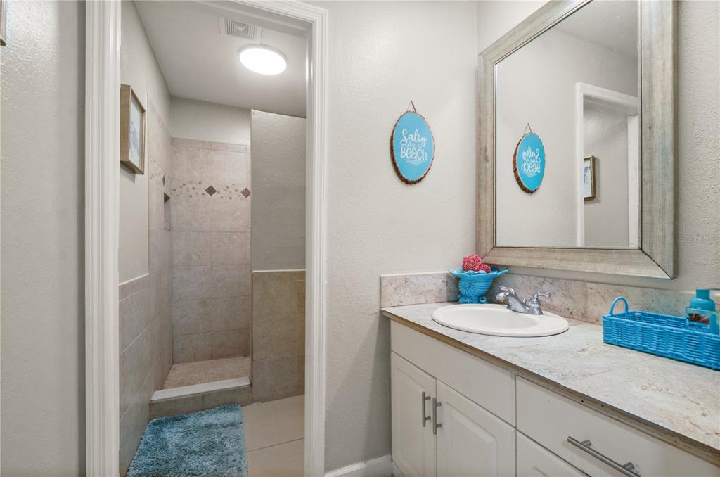 209 7th Street South Dundee, FL 33838 - Photo 25 of 36 a bathroom with a sink a mirror and a shower