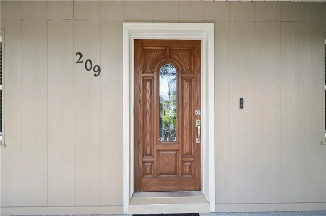 a front view of a entryway door with a mirror
