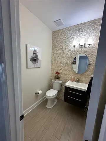 a bathroom with a toilet a sink and mirror