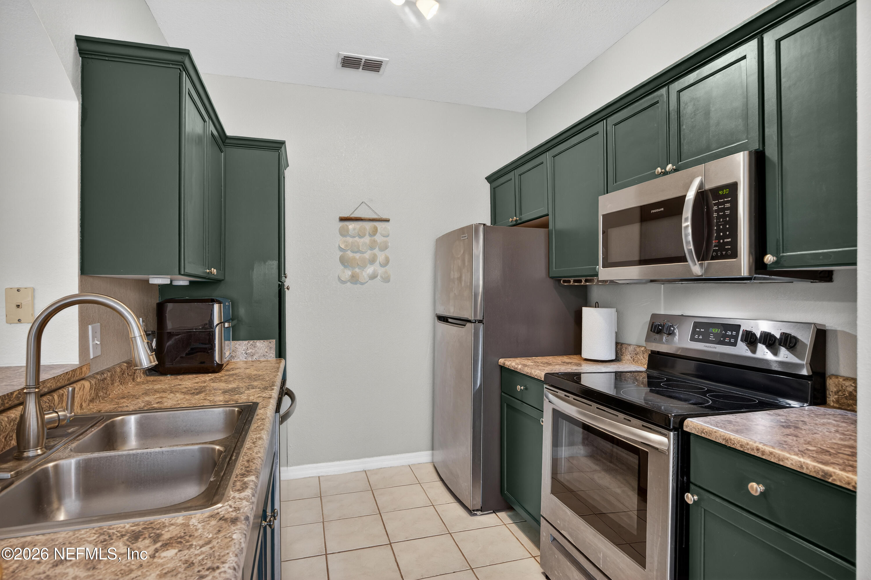 10961 Burnt Mill Road, Unit 1524 Jacksonville, FL 32256 - Photo 10 of 38 a kitchen with stainless steel appliances granite countertop a sink stove and refrigerator