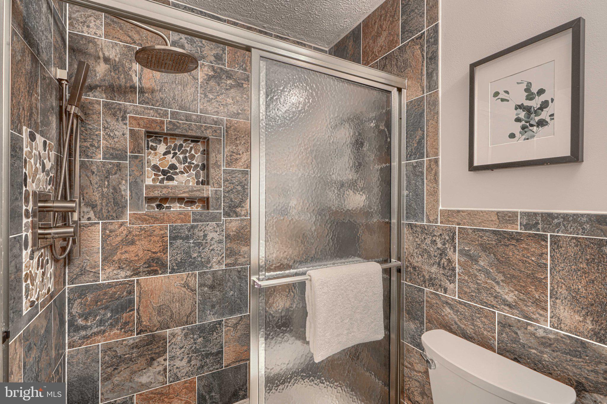 3460 Brookhaven Road Pasadena, MD 21122 - Photo 12 of 27 Elegant stone-tiled shower retreat.