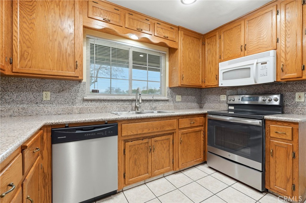 2826 East Hampton Way Fresno, CA 93726 - Photo 11 of 29 a kitchen with stainless steel appliances granite countertop a sink stove and cabinets