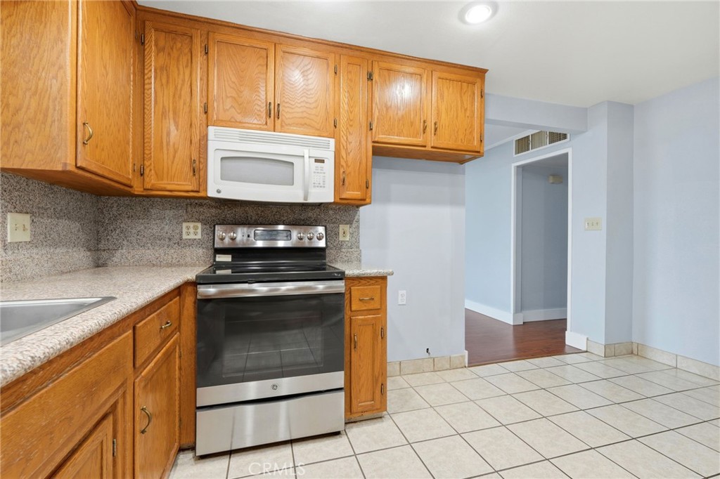 2826 East Hampton Way Fresno, CA 93726 - Photo 13 of 29 a kitchen with granite countertop cabinets stainless steel appliances and a sink
