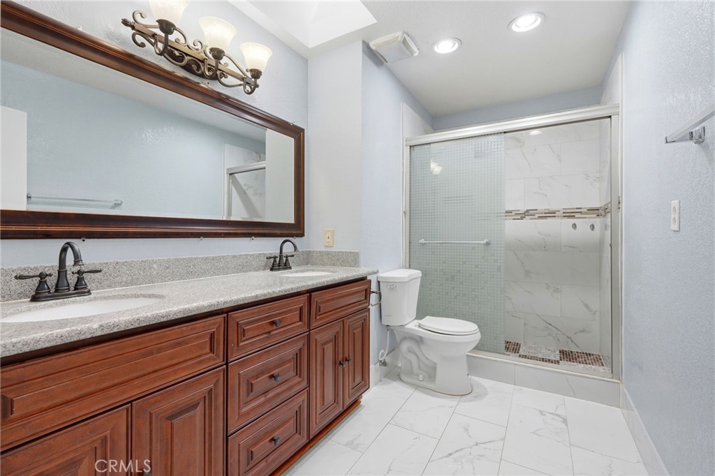 2826 East Hampton Way Fresno, CA 93726 - Photo 17 of 29 a bathroom with a double vanity sink and a toilet