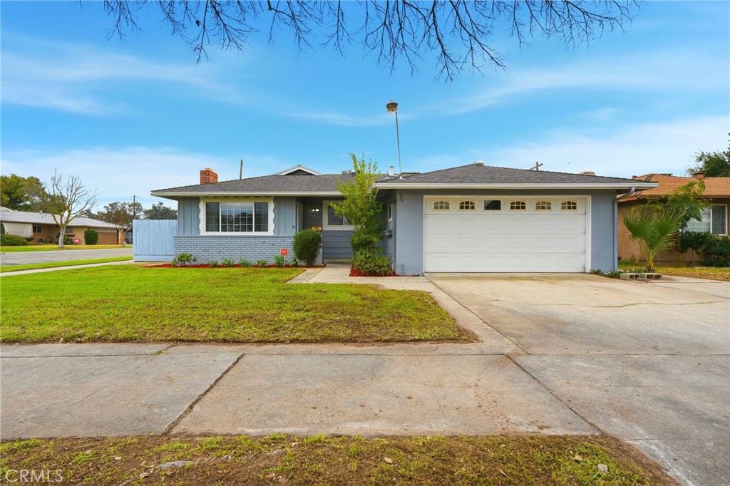 2826 East Hampton Way Fresno, CA 93726 - Photo 2 of 29 a front view of a house with a yard and garage