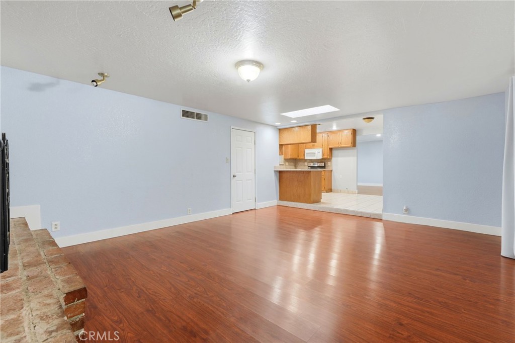2826 East Hampton Way Fresno, CA 93726 - Photo 9 of 29 a view of empty room with wooden floor and fan