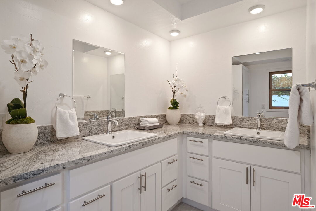 543 Westmount Drive West Hollywood, CA 90048 - Photo 21 of 44 a bathroom with a granite countertop sink and a mirror