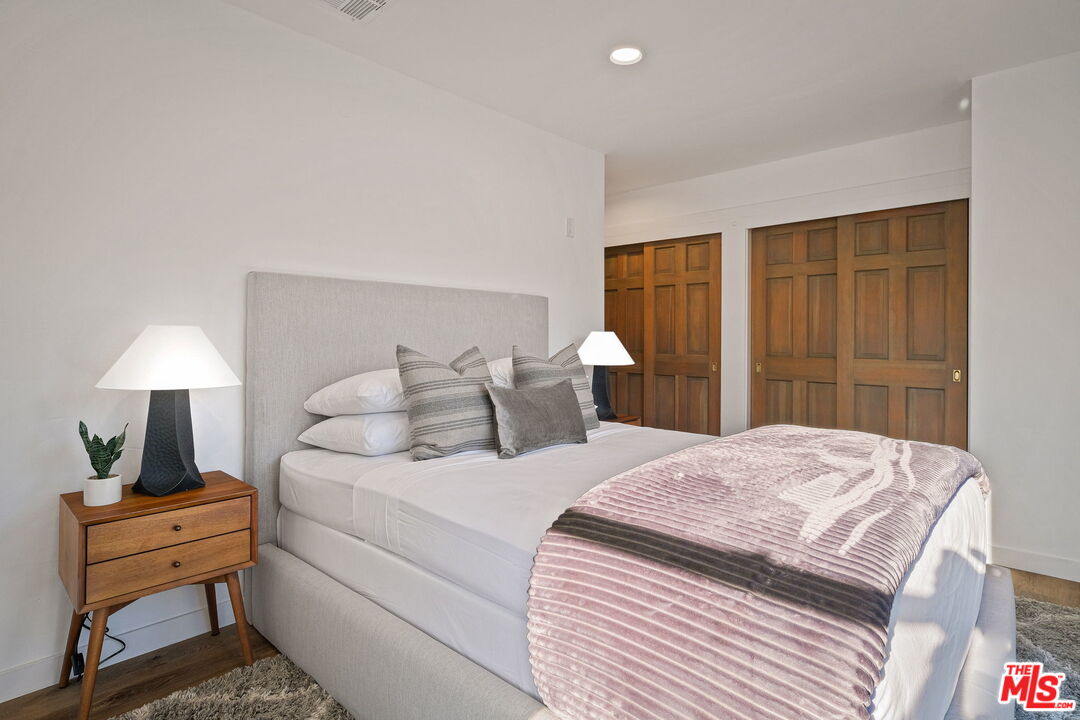 543 Westmount Drive West Hollywood, CA 90048 - Photo 28 of 44 a bedroom with a bed and wooden floor