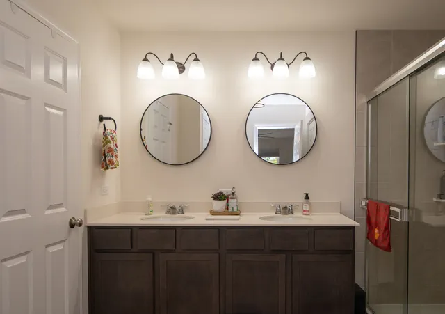 a bathroom with double vanity sinks and a mirror
