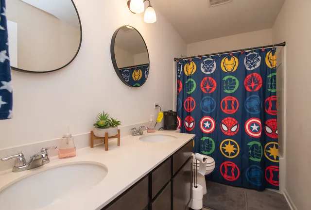 a bathroom with a sink a mirror and painting on the wall