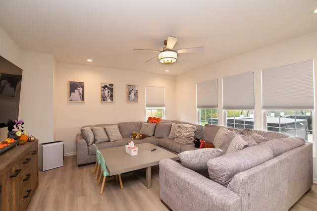 a living room with furniture a flat screen tv and a window