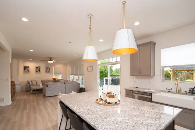 a kitchen with stainless steel appliances granite countertop a stove a kitchen island and a refrigerator