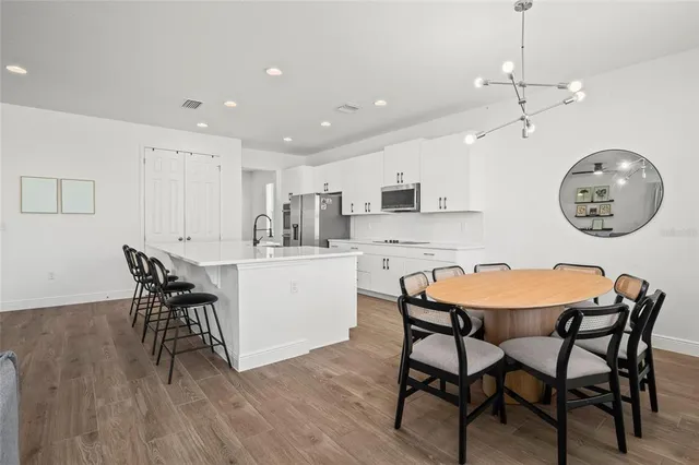 a kitchen with stainless steel appliances a refrigerator sink and white cabinets