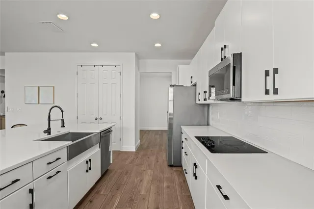 a kitchen with kitchen island a stove a table and chairs in it