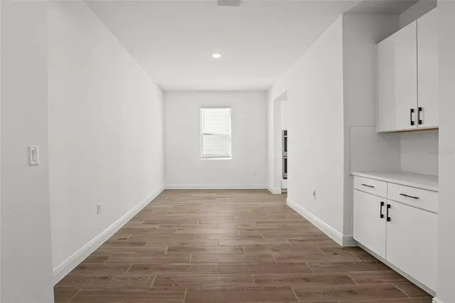 a bedroom with a large bed a chandelier and windows