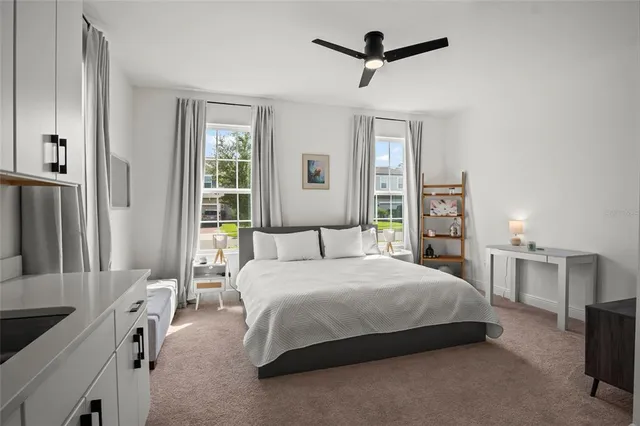 a bedroom with a bed and a ceiling fan
