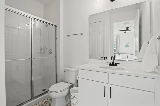 a spacious bedroom with a bed and a ceiling fan