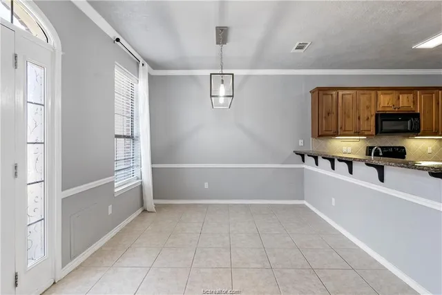 a kitchen with a refrigerator and a stove top oven