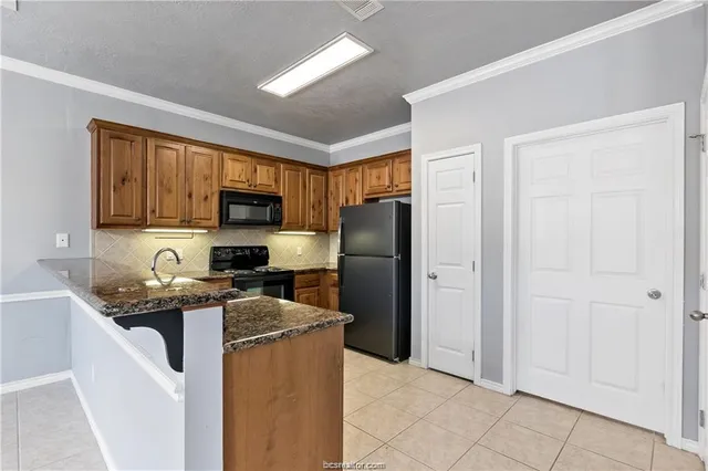 a kitchen with stainless steel appliances granite countertop a refrigerator stove and sink