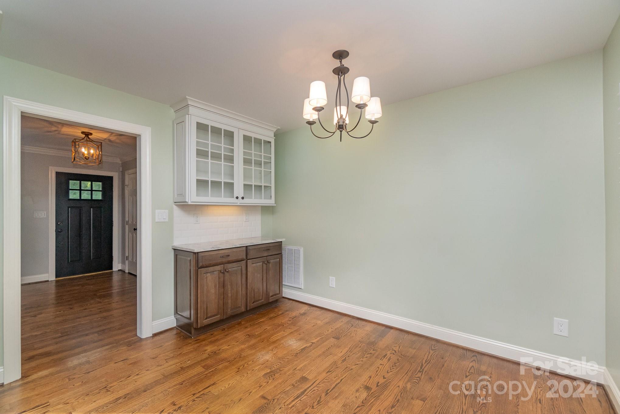 1008 Dumbarton Road Gastonia, NC 28054 - Photo 11 of 39 an empty room with wooden floor and cabinet