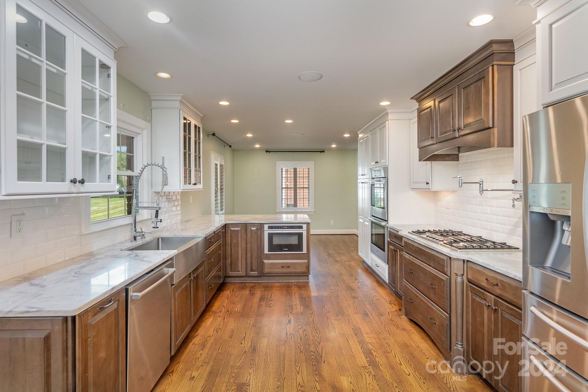 1008 Dumbarton Road Gastonia, NC 28054 - Photo 7 of 39 a kitchen with stainless steel appliances granite countertop a stove top oven a sink dishwasher a refrigerator and a cabinets with wooden floor