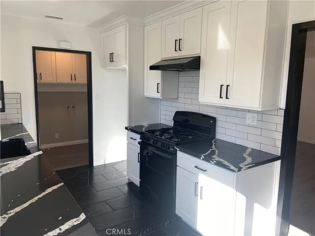 a kitchen with granite countertop a stove and a refrigerator