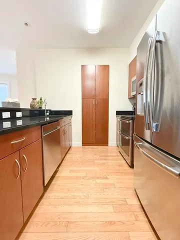 a kitchen with stainless steel appliances granite countertop a refrigerator and a stove top oven